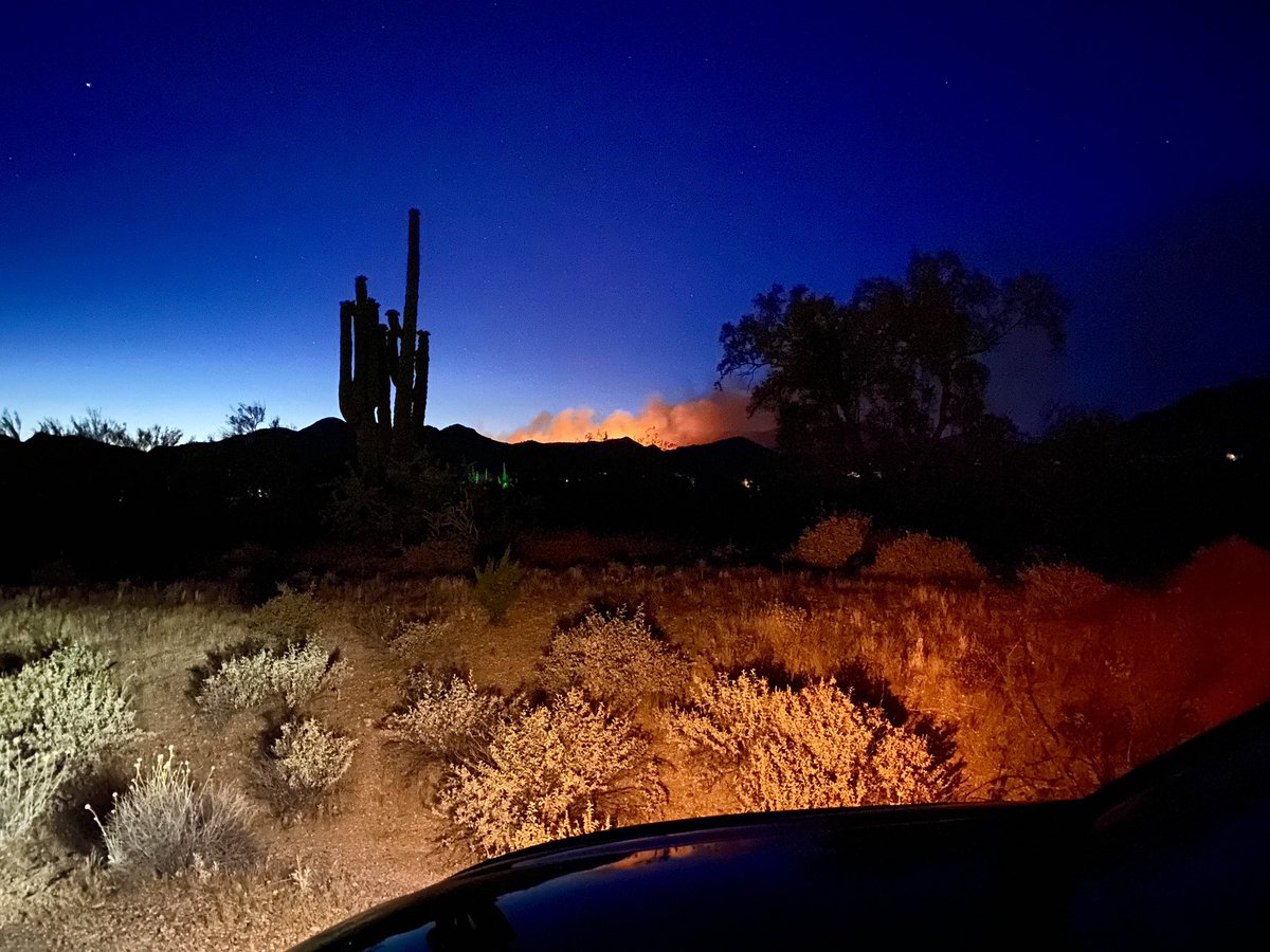 The glow of the East Desert Fire burning in the distance at dusk